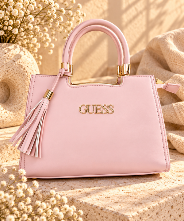 Bolso rosa de mano con detalles dorados y borla decorativa