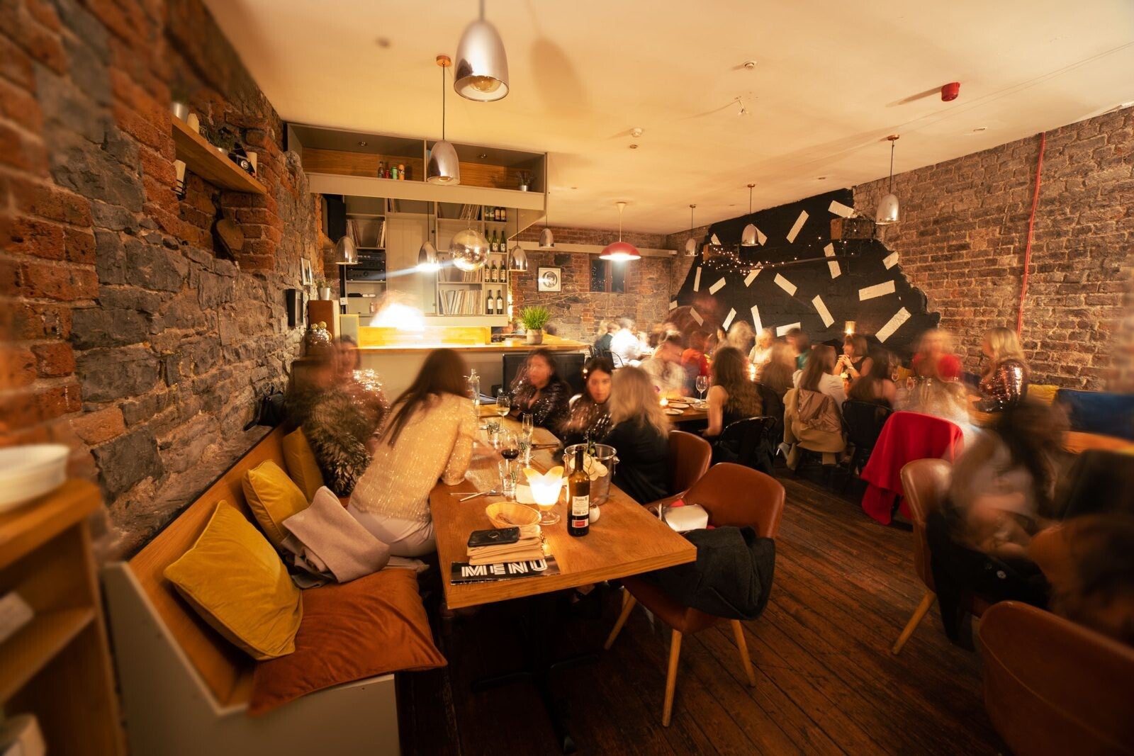 Guests dining by candlelight in the brick-walled room at Melody, Limerick
