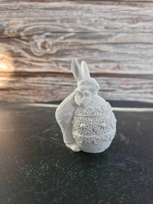 Osterhase auf Ei lehnend