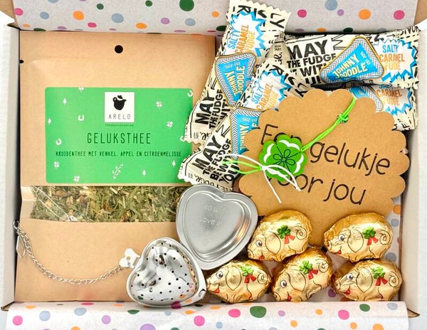 Postkadootje Gelukspakket | Geluksthee in zakje | Theefilter met uitlekschaaltje | Johnny Doodle caramelblokjes | Gelukszwijntjes chocolade | Gelukje voor jou klavertje vier | Kaartje naar keuze