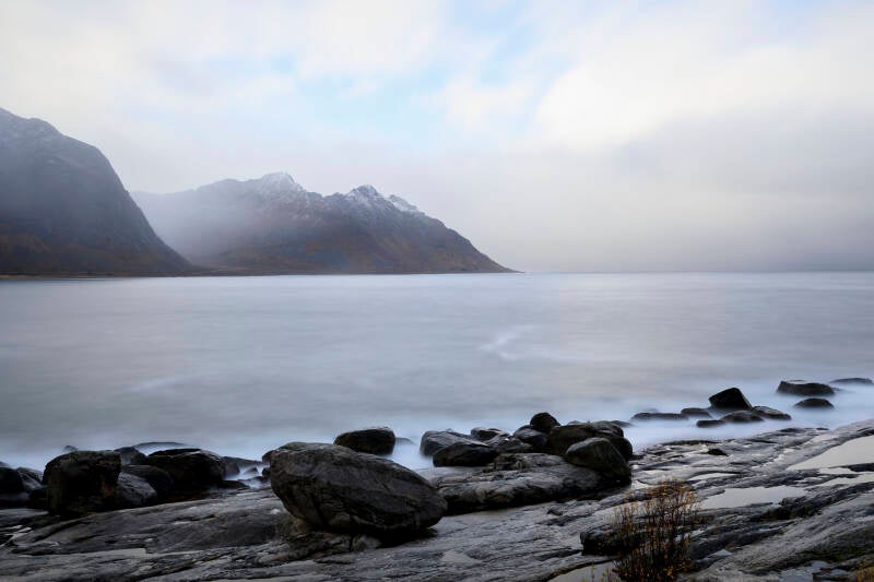 Zicht vanaf Kaldfarnes op besneeuwde bergen