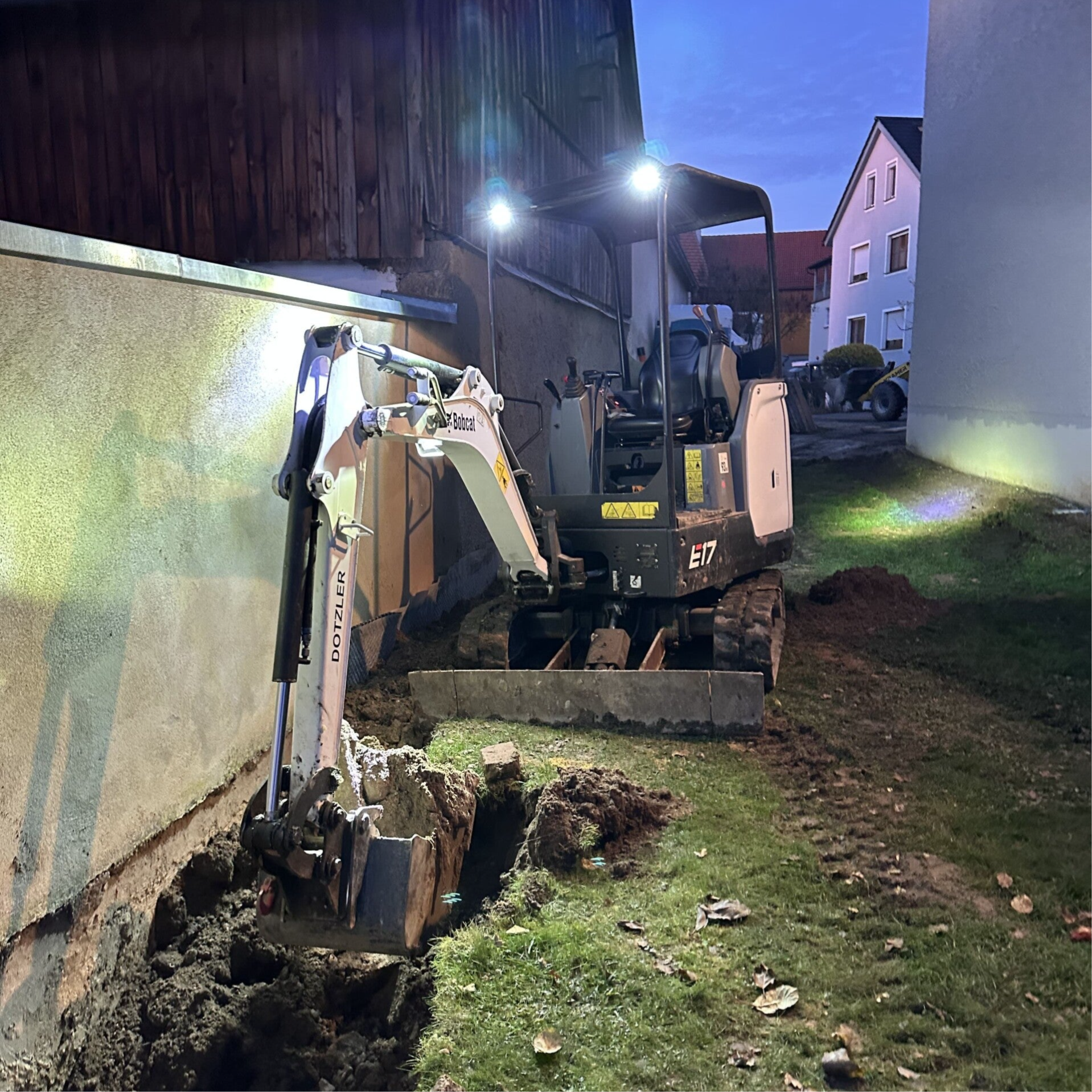 Minibagger bei Baggerarbeiten, in diesem Fall die Freilegung einer Mauer zur anschließenden Trockenlegung durch Erdarbeiten von Dienstleistungen Dotzler in Hirschau