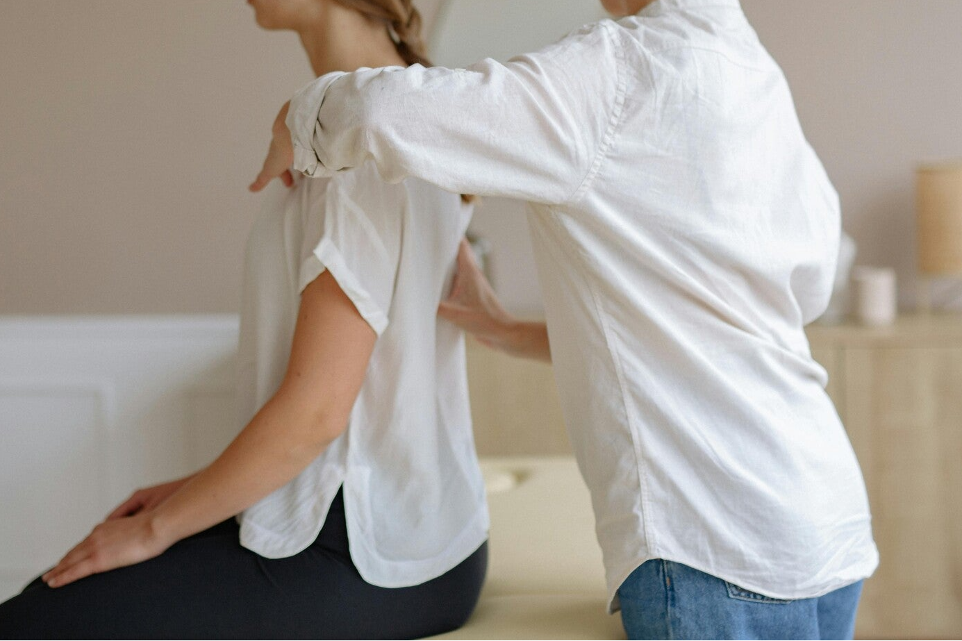 Oefentherapeut onderzoekt patient bij rug en borst