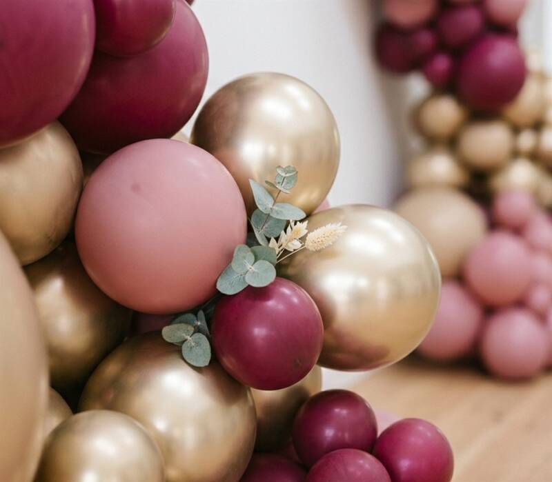Close-up detail of balloon garland in dusty pink, burgundy and gold