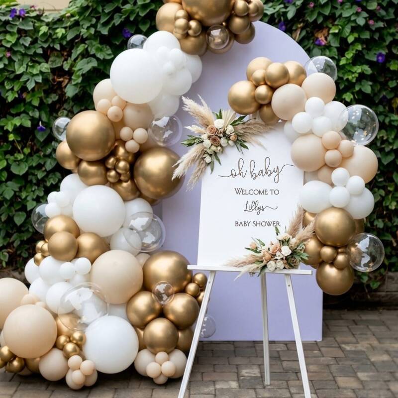 White and gold balloon garland framing an "Oh Baby" baby shower welcome sign