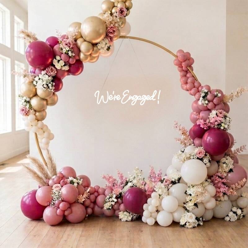 Pink, burgundy and gold balloon hoop display with fresh florals for an engagement celebration