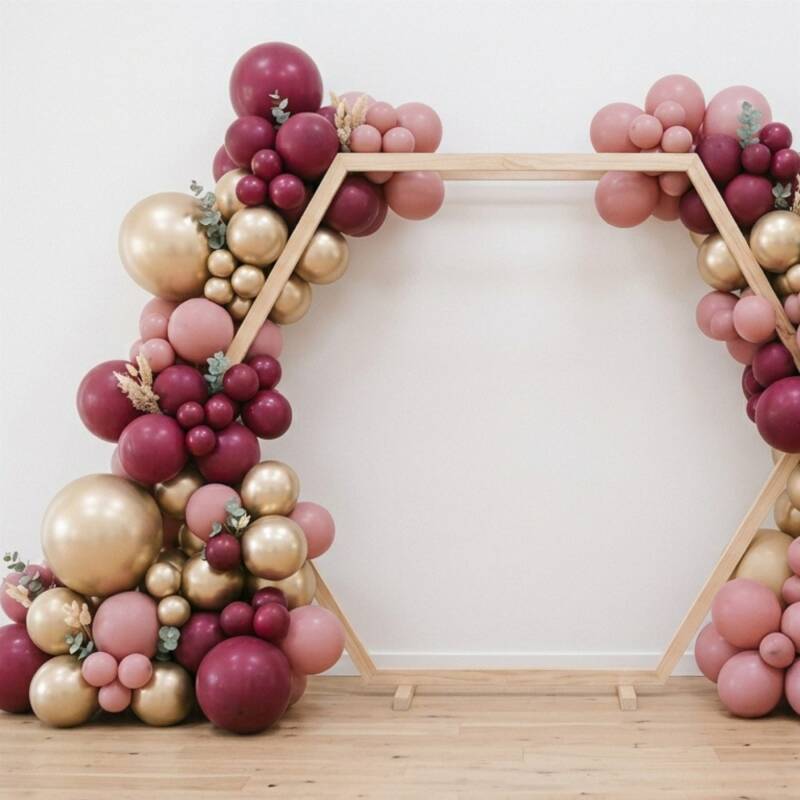 Hexagon wedding arch styled with a blush, burgundy and gold balloon garland and eucalyptus