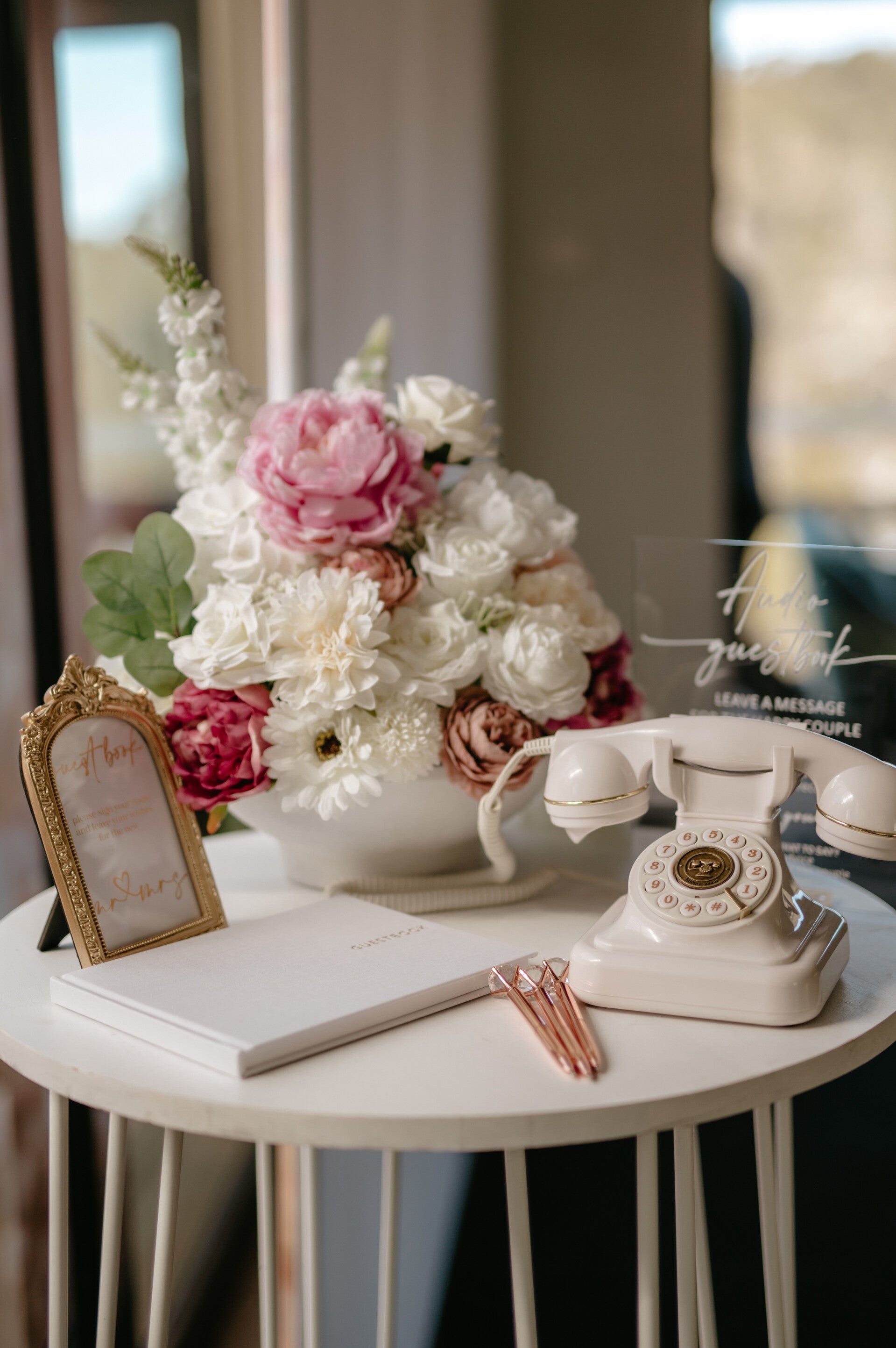 Styled guest book table with florals and a vintage telephone