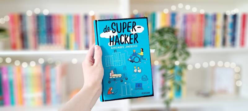 Een witte hand houdt 'De superhacker' van Annemarie Jongbloed omhoog voor een kleurrijke wazige boekenkast met lichtejs. Recensie door turnthepages.nl | Rolstoelgebruiker, disabled bookstagrammer en boekblogger met ADHD.