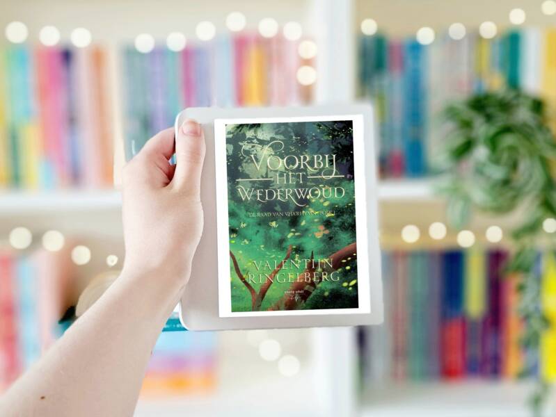 Een witte hand houdt 'Voorbij het wederwoud' van Valentijn Ringelberg omhoog voor een kleurrijke wazige boekenkast met lichtjes. Foto bij own-voices recensie door turnthepages.nl Disabled bookstagrammer en blogger.