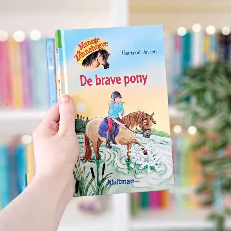 Een witte hand houdt 'precies wat ik miste' van Hannah Bonam-Young ohoog voor een kleurrijke wazige boekenkast met lichtjes. Recensie door Annemarie van turnthepages.nl | Disabled bookstagrammer en boekblogger.