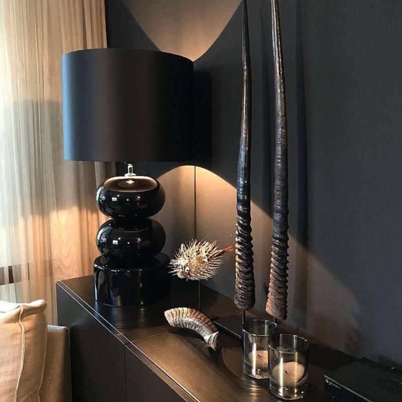 Een zwarte lampenkap op een chique tafellamp