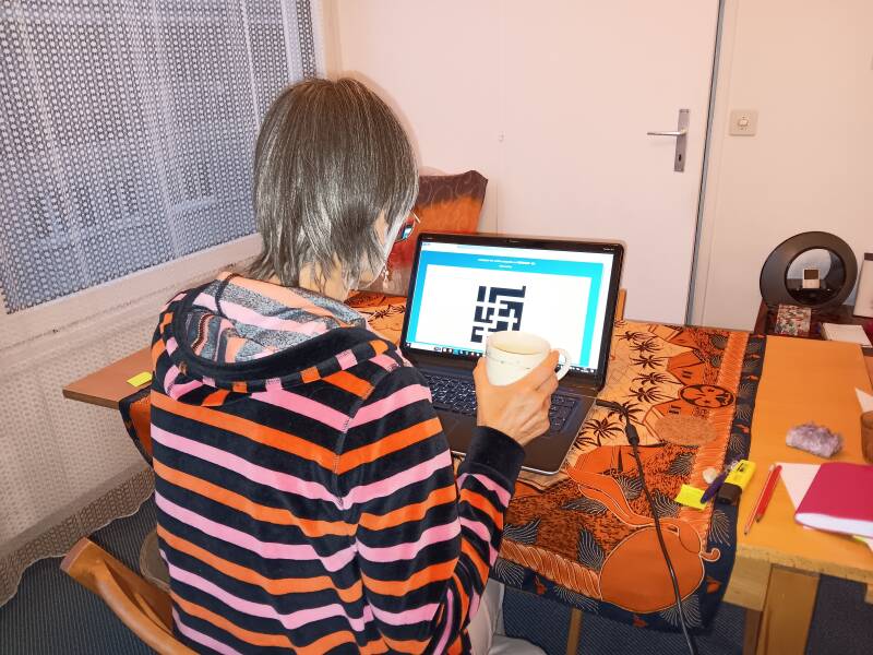 Femme devant un ordinateur et buvant un thé