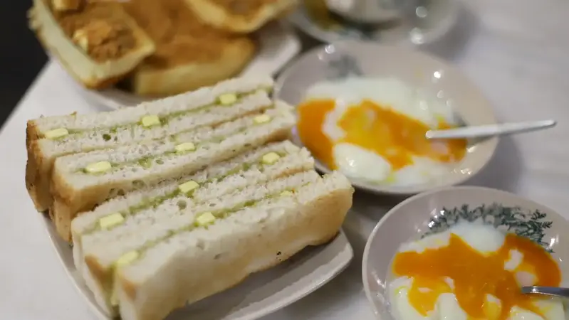 desayuno con tostadas de kaya y mantequilla, huevos poché y café