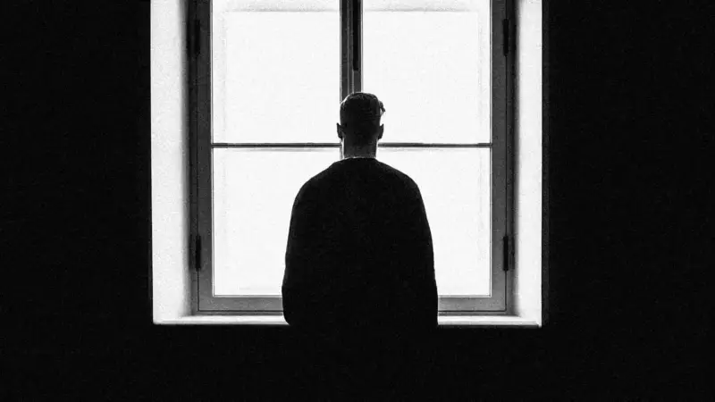 un empleado que mira por una ventana mientras se siente vacío