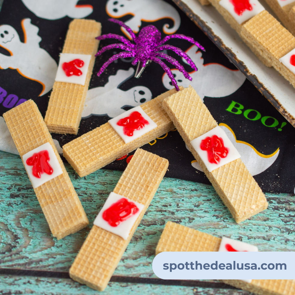 Vanilla wafer Halloween treat made to look like a bloody bandage using white fondant and red food gel
