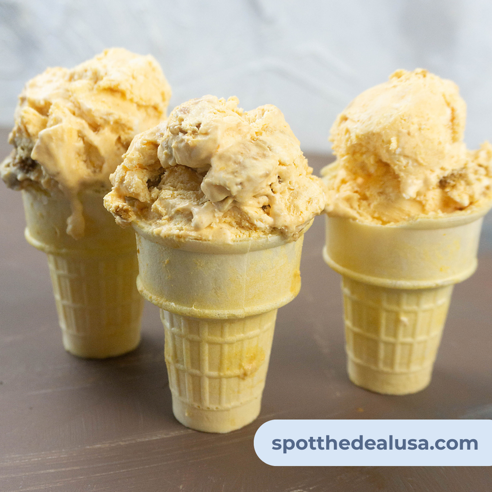 A scoop of pumpkin ginger snap no-churn ice cream in a waffle cone, topped with cookie crumbles and served in a cozy fall setting.