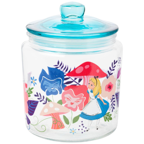 Alice in Wonderland-themed glass cookie jar with lid, featuring Disney flowers and mushrooms, filled with cookies on a white background.