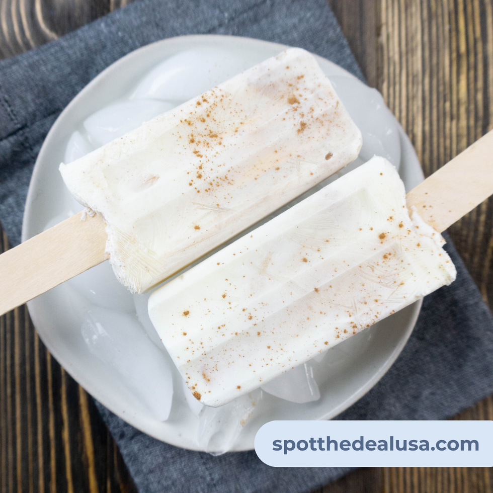 Creamy apple pie popsicles with visible apple pieces and a dusting of cinnamon, served on a fall-themed plate or rustic tray.