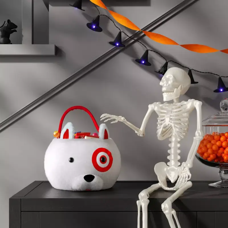 Target Bullseye Dog Halloween trick-or-treat bucket sitting on a table next to a Halloween skeleton.