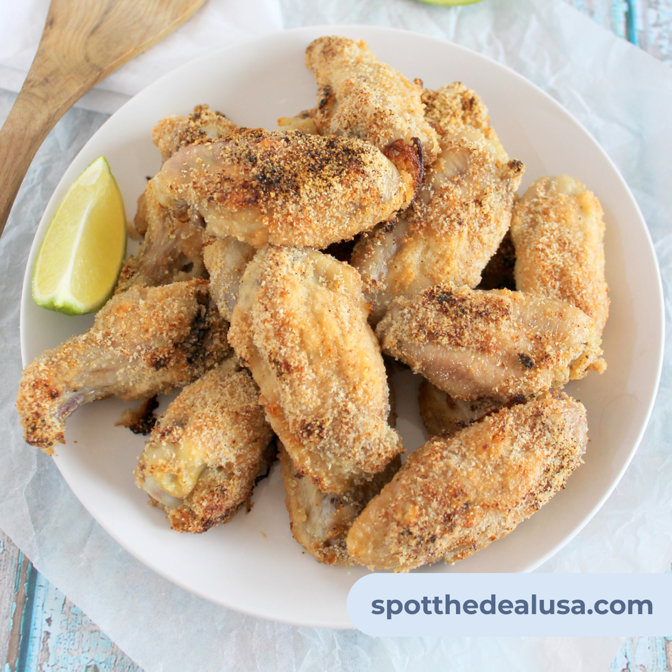 Keto Lemon Pepper Chicken Wings on a white plate with a wedge of lemon.
