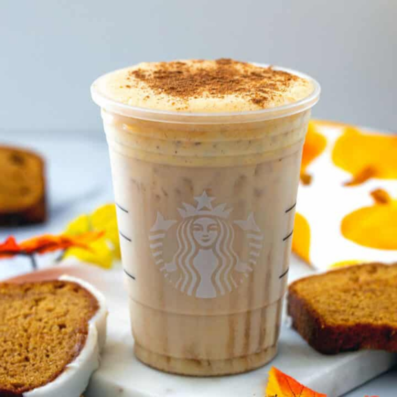 A Starbucks Pumpkin Spice Latte in a cozy autumn setting