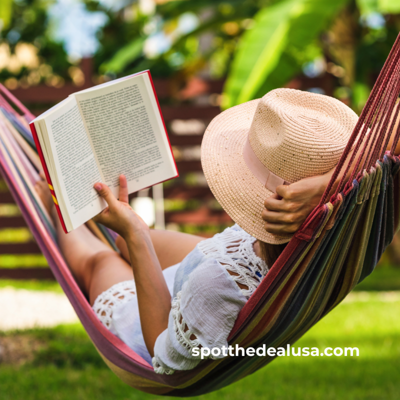 A woman relaxing in a hammock on a sunny day, reading a book with trees and blue sky in the background—summer reading vibes.