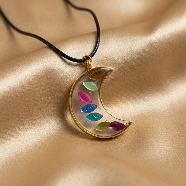Gold tone crescent moon pendant, multicolor enamel leaf, black cord necklace