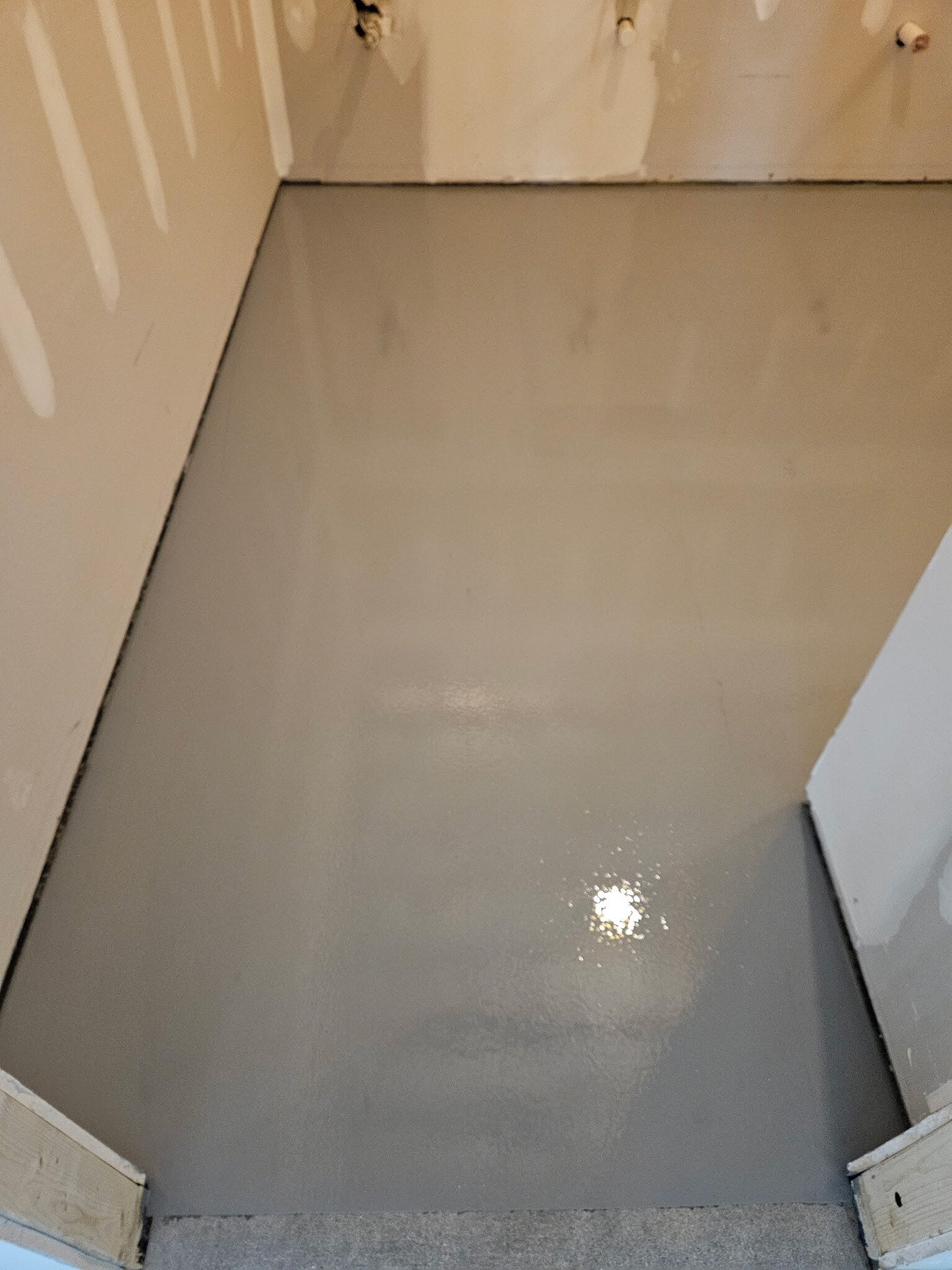 Commercial epoxy floor coating beside finished drywall