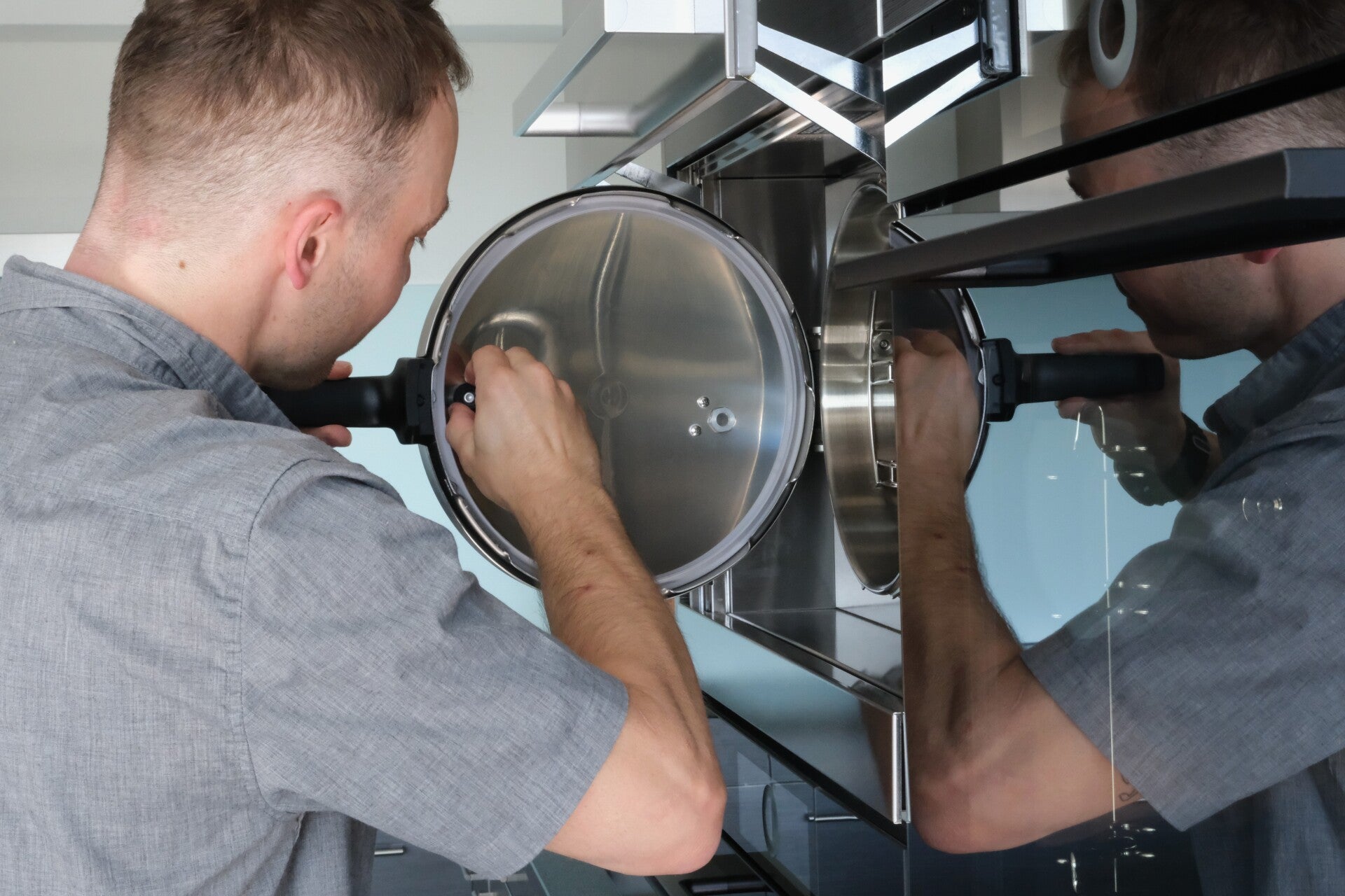 Servicetechniker inspiziert und wartet die Türdichtung eines eingebauten Dampfgarers.