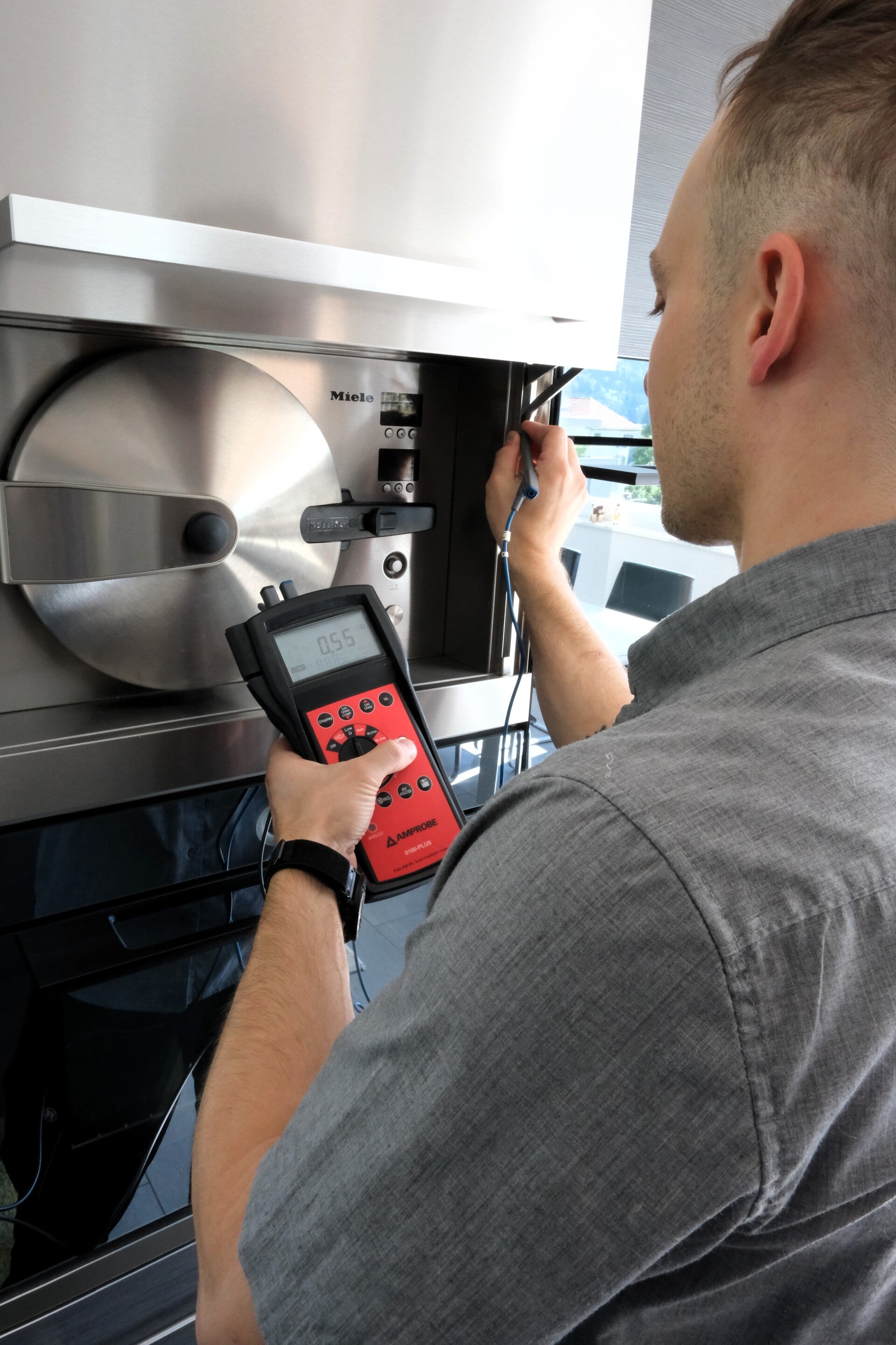 Elektrische Sicherheitsprüfung nach der Reparatur eines Küchengeräts mit einem digitalen Prüfgerät.