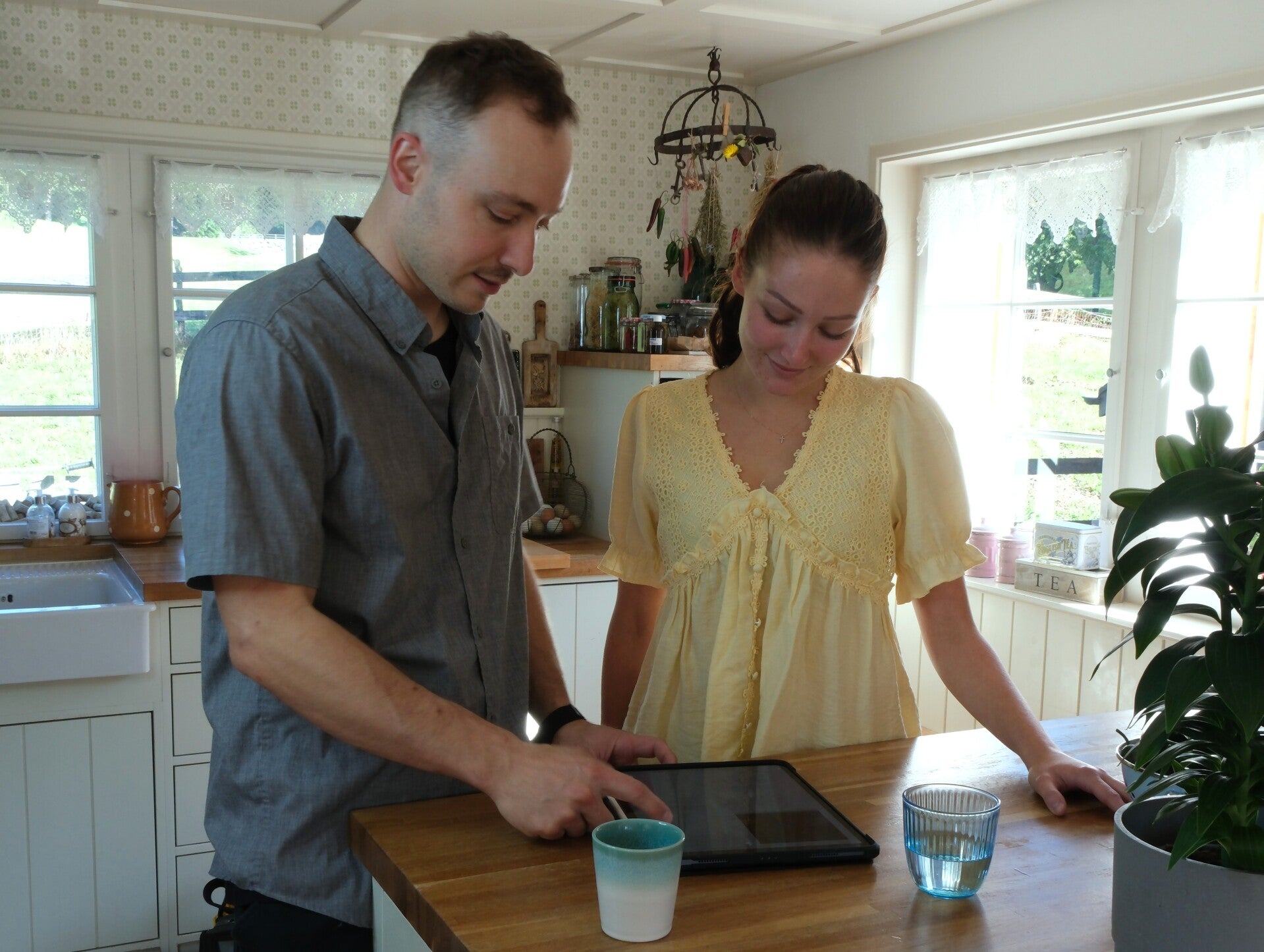 Persönliche digitale Beratung: Techniker bespricht die Gerätedaten auf dem Tablet mit der Kundin.