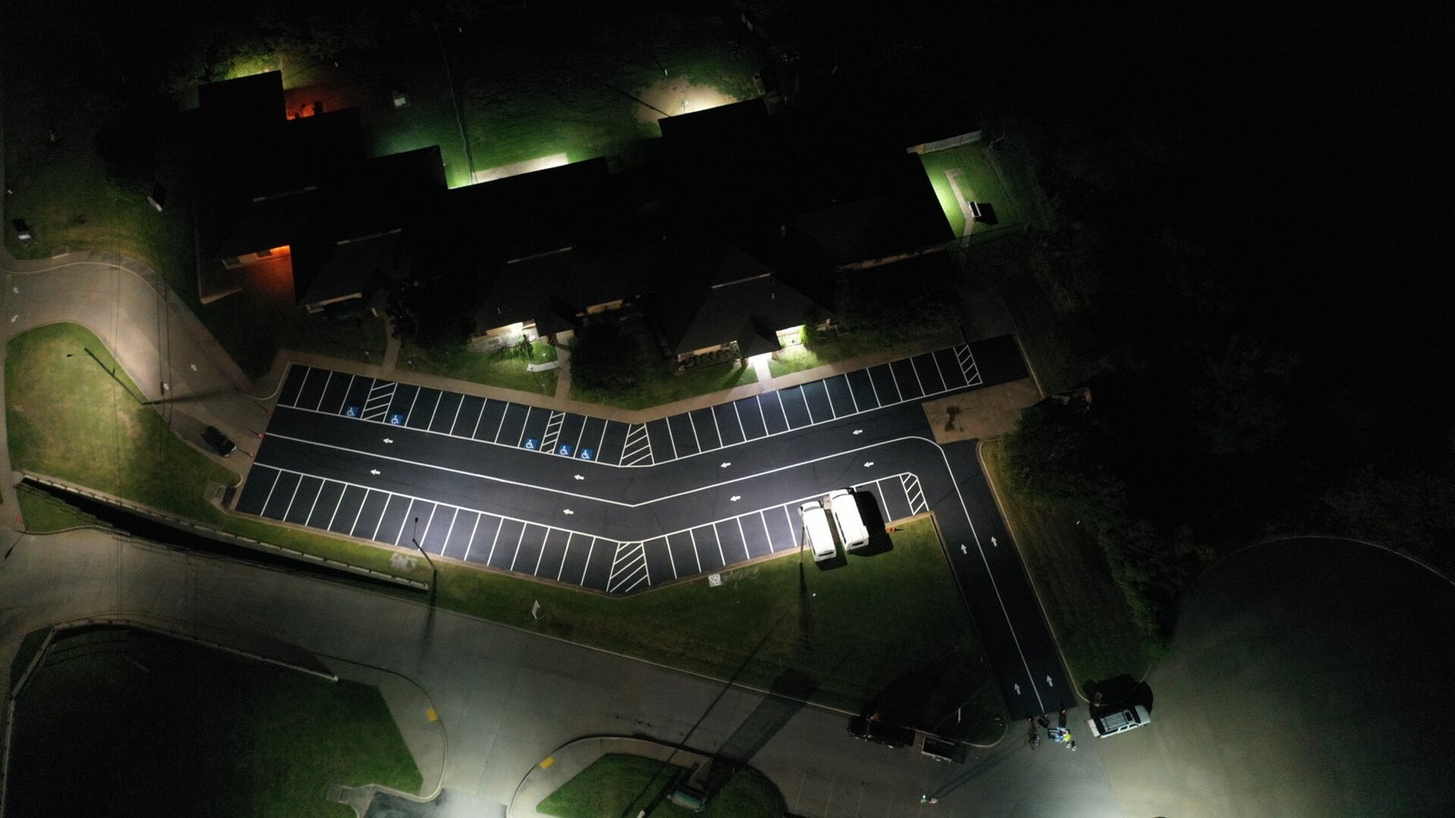 Aerial view of a freshly striped parking lot with marked spaces, access aisles and directional arrows