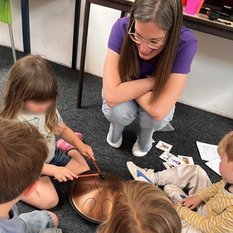 Kinderen zitten in een kring rondom de tonguedrum tijdens de workshop ‘Ik ben ik, en dat is goed’ van Bewust & Wijs in Zwolle