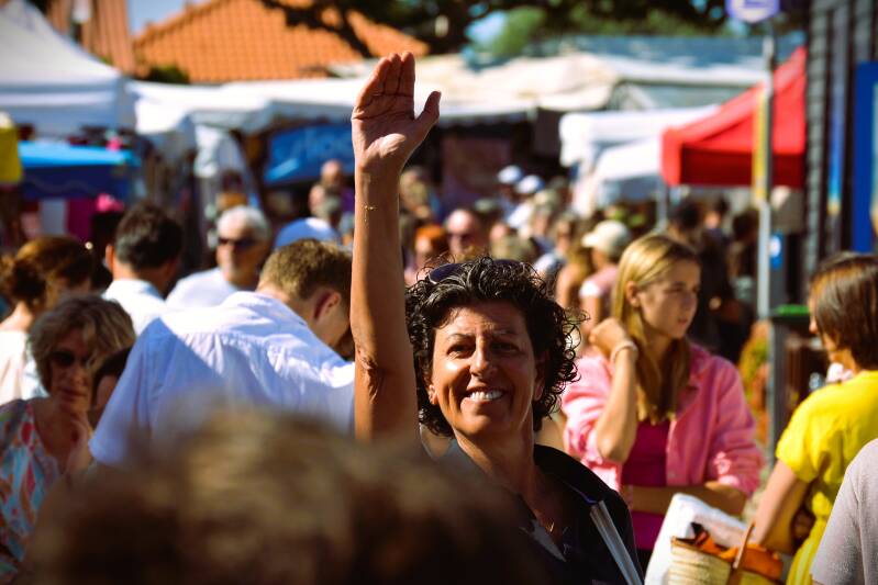 c'est le portrait d'une femme qui lève la main sur le marché de noirmoutier 