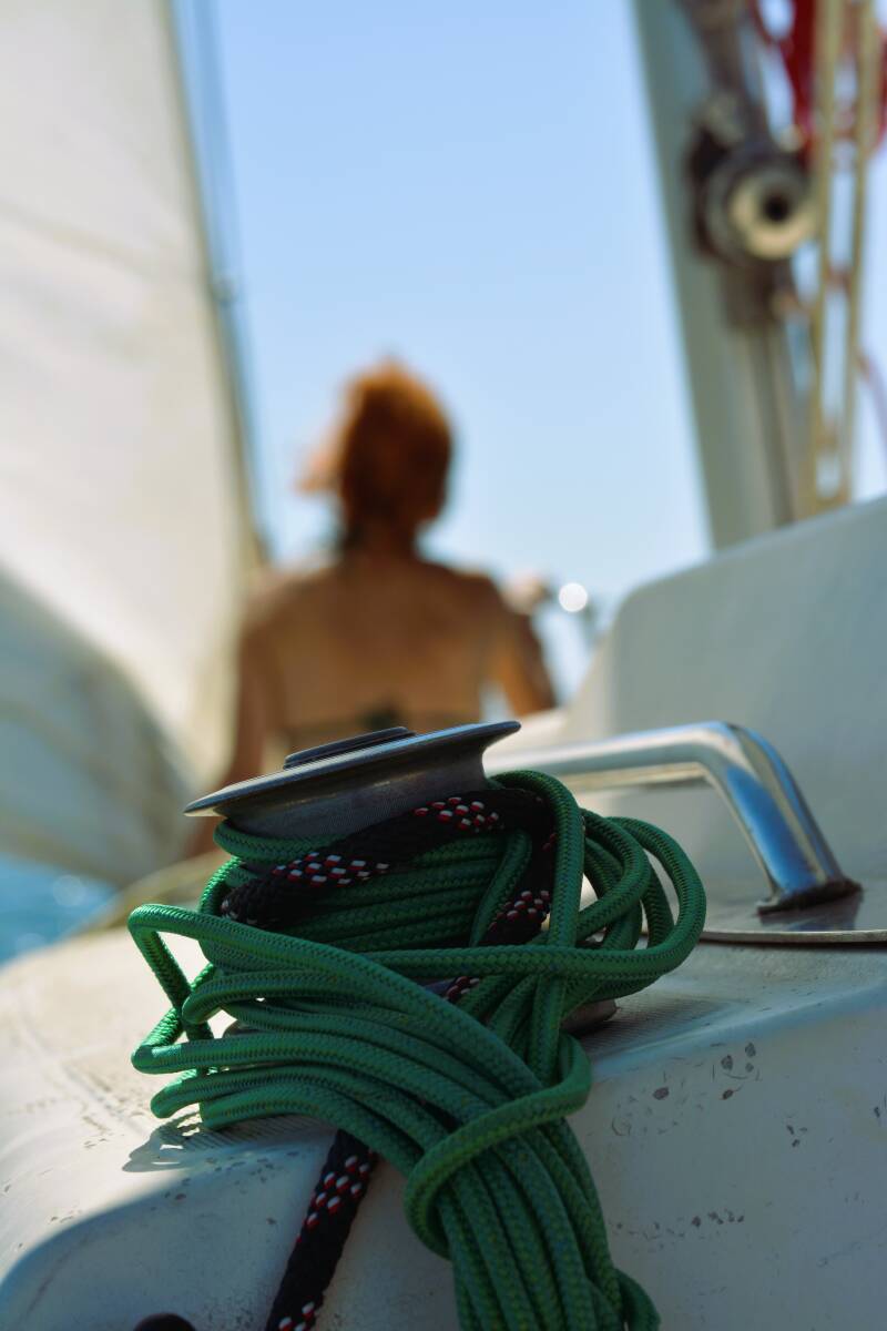 photo floutée d'une femme rousse à l'avant d'un voilier
