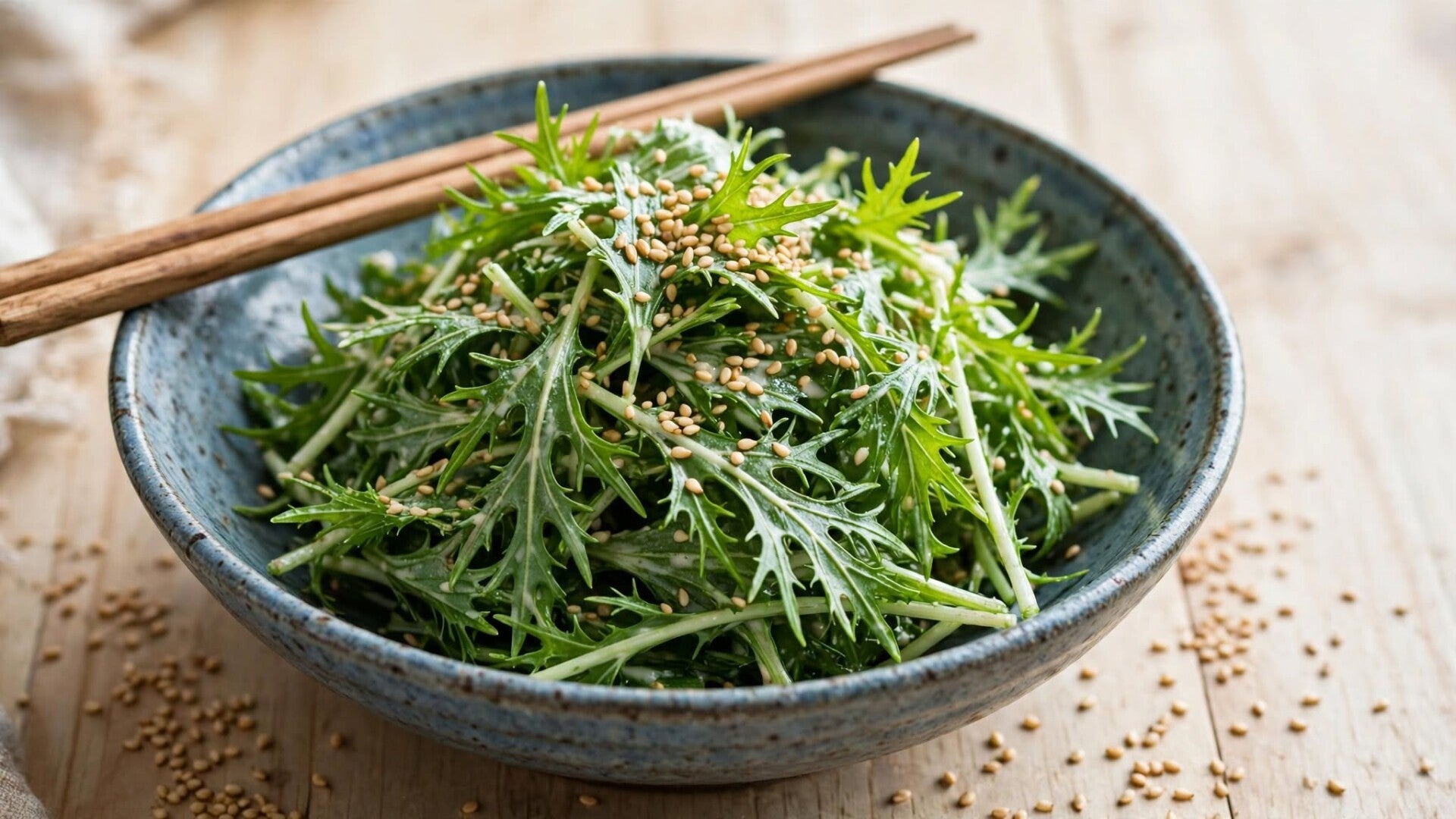 Japansk mizuna baby leaf gomaae sallad med sesam i keramikskal med atpinnar