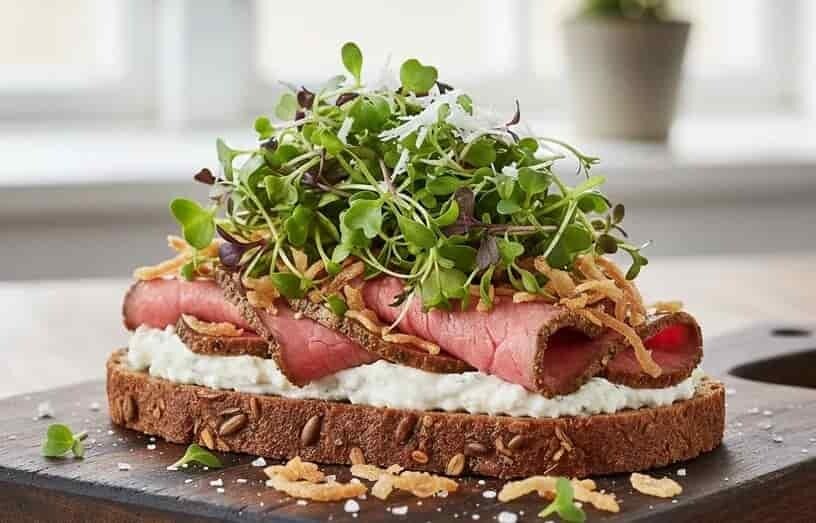 Rostbiffsmörgås toppad med peppriga krasseskott (mikrogrönt) och rostad lök. Odla microgreens med fröer från HCT Seeds.