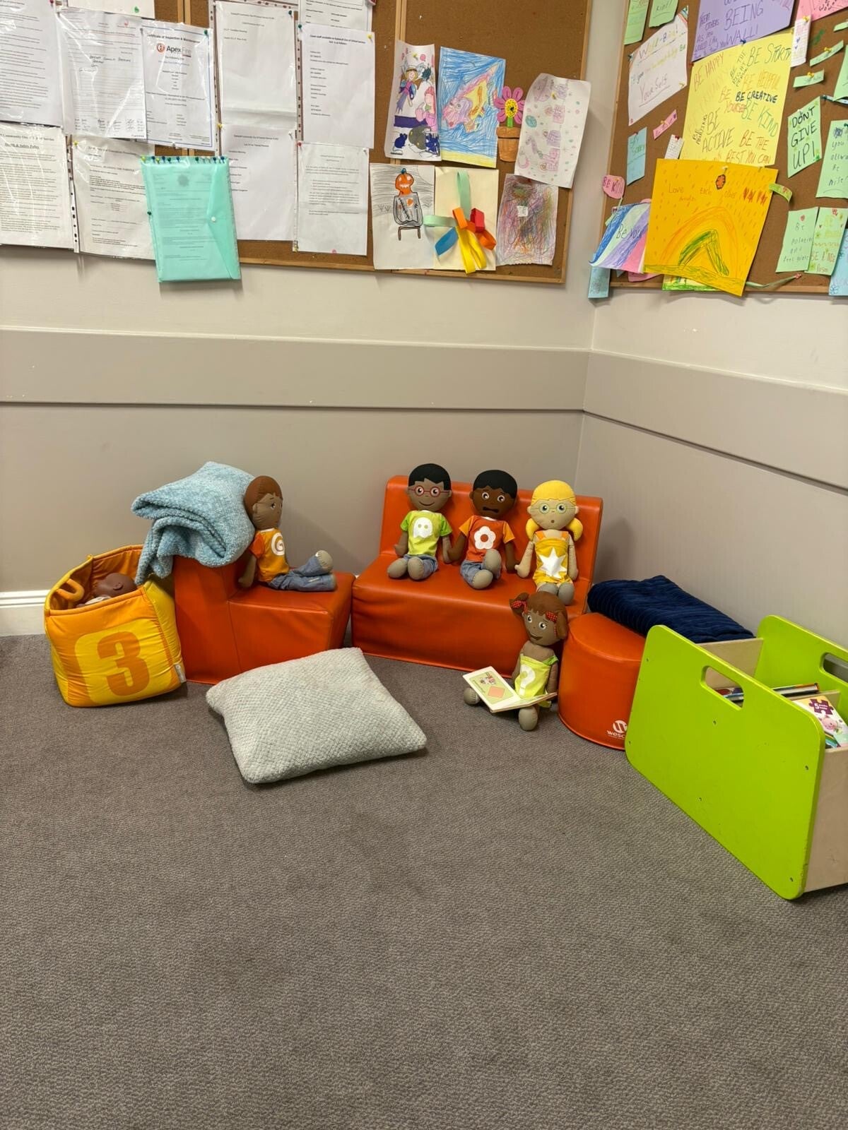 An area of Room 2 with some childrens sofas displaying 5 dolls.