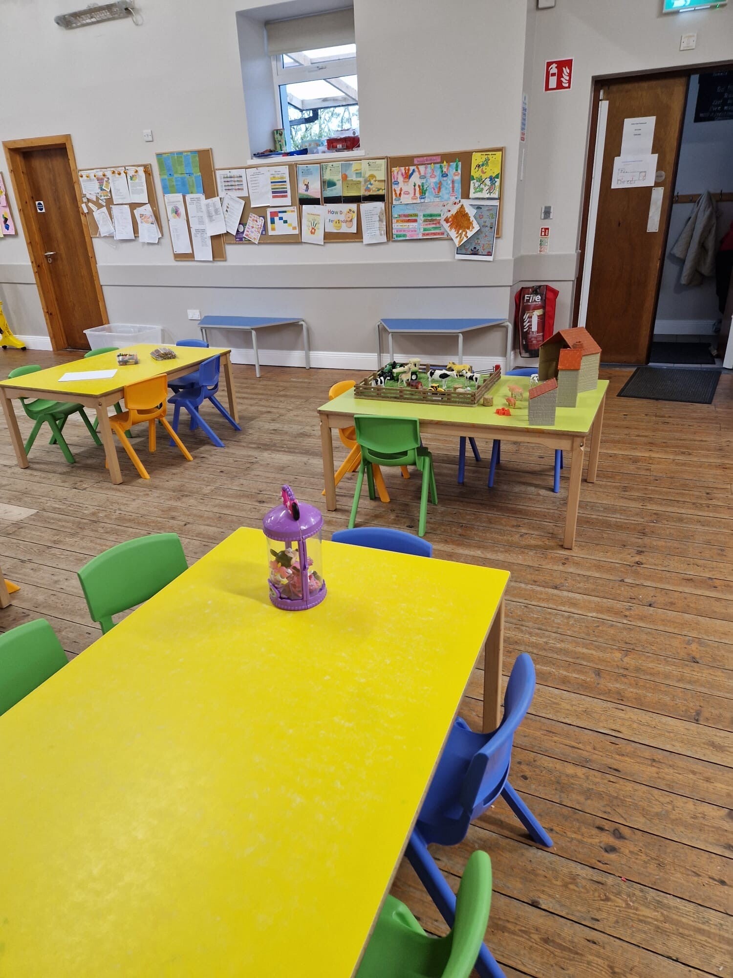 A view of Room 2 with small tables na dchairs laid out for the children.