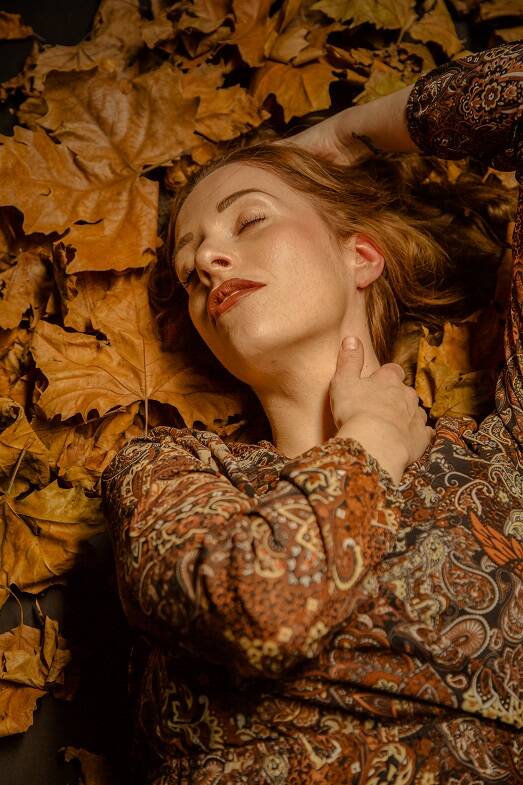 model ligt op herfst bladeren