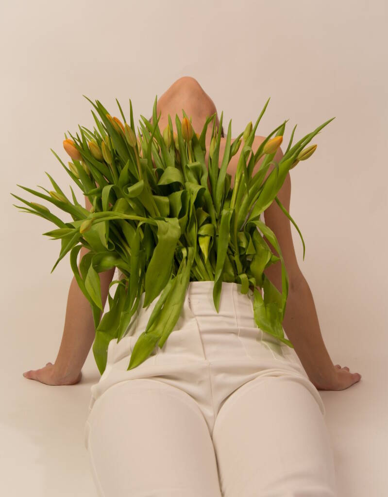 model met tulpen in broek hoofd achterover