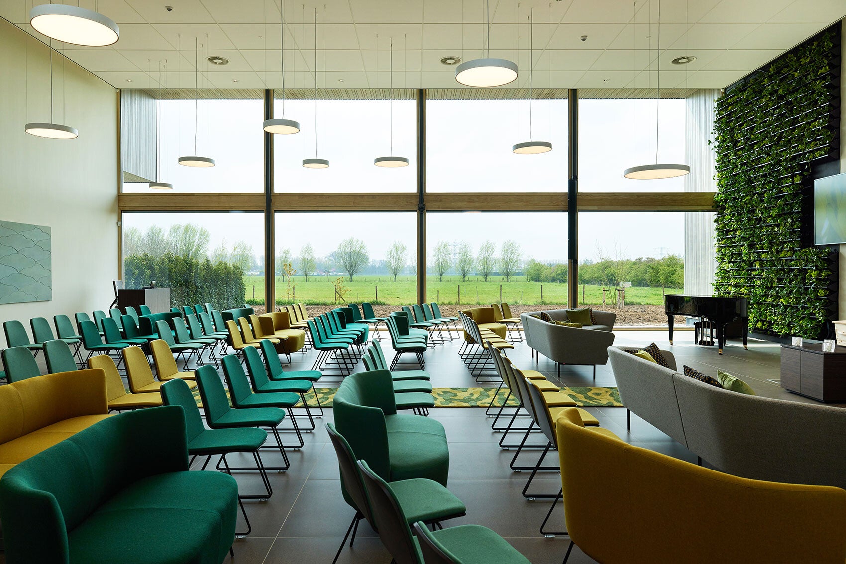 Zaal van een crematorium moderne inrichting met uitzicht op de wielanden rondom het gebouw