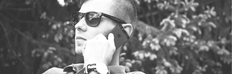 Persoon belt met mobiel aan het oor naar aanleiding van een overlijden met de uitvaartondernemer met de vraag hem bij te staan bij de uitvaart.