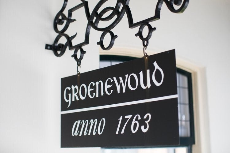 Uithangbord aan de gevel van gebouw Groenwoud met het jaartal 1763 erop.