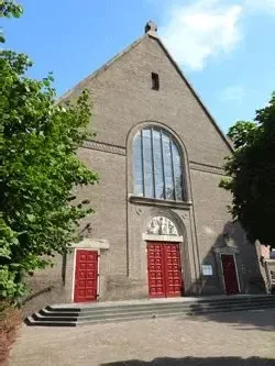 Ingang Rooms katholieke kerk in Wageningen  met trap naar de ingang bestaande uit rode toegangsdeuren.