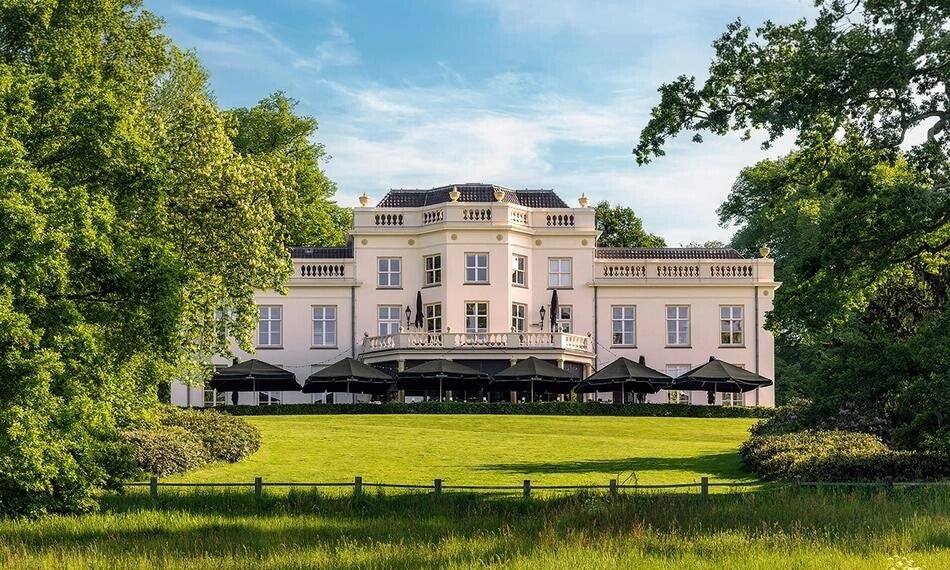 Een stijlvolle uitvaartlocatie authentiek landhuis met gras ervoor.