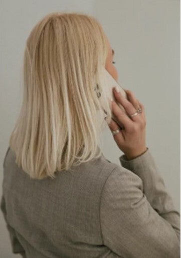 Vrouw met blond haar met mobiele telefoon aan het oor