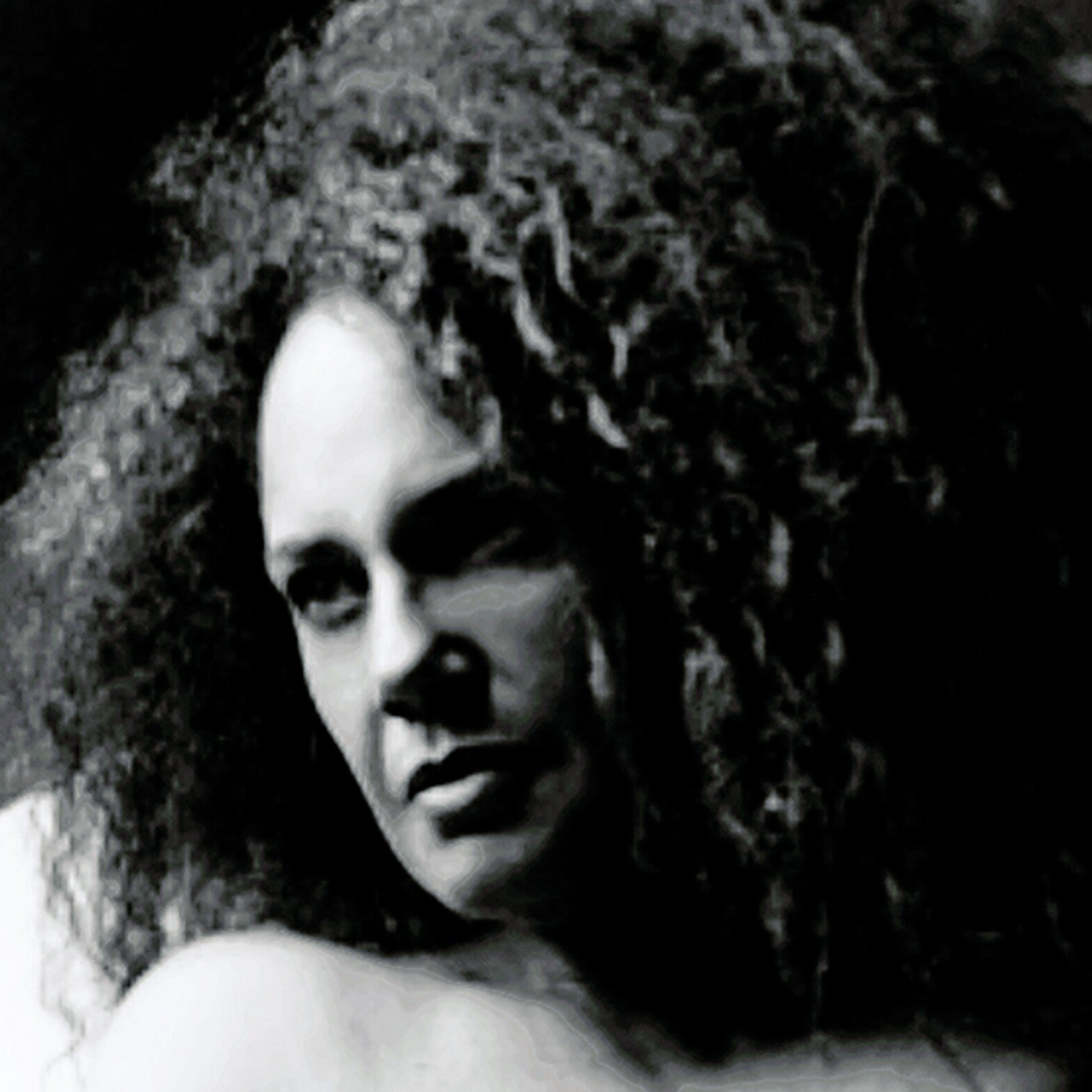 Portrait en noir et blanc de Nathaly Coualy, le visage à demi éclairé, regardant l’objectif. signe jean-marie-marion