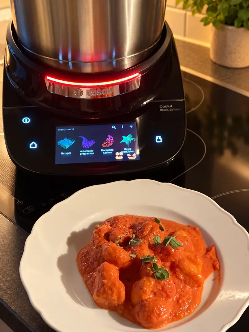 Rinderfilet mit Gnocchi in Tomaten-Sahne-Sauce auf einem weißen Teller vor dem Bosch Cookit.